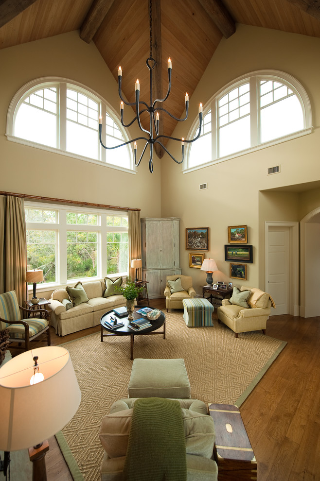 This is an example of a traditional formal living room in Charleston with beige walls, medium hardwood floors, a standard fireplace, a stone fireplace surround and no tv.