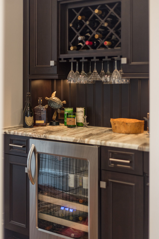 Inspiration for a small transitional single-wall wet bar in Charlotte with no sink, quartzite benchtops, timber splashback, dark hardwood floors, brown splashback, grey cabinets and recessed-panel cabinets.