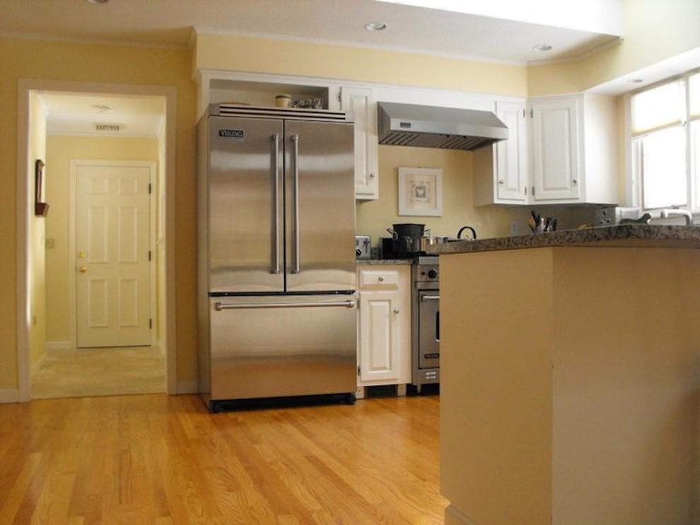 Mid-sized transitional light wood floor kitchen photo in Boston with raised-panel cabinets, white cabinets, granite countertops and stainless steel appliances