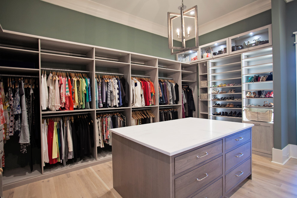 Inspiration for a large transitional women's dressing room in Atlanta with flat-panel cabinets, dark wood cabinets and light hardwood floors.