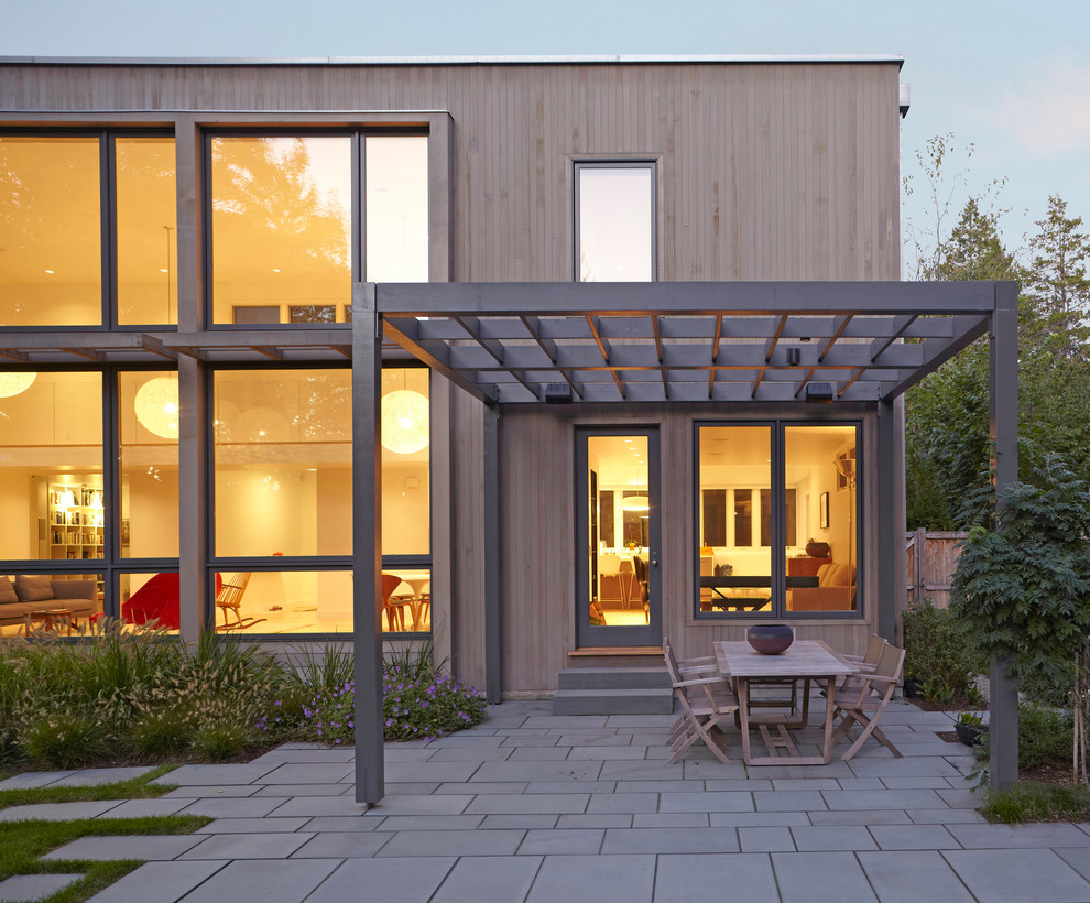 Design ideas for a contemporary patio in Boston with concrete pavers and a pergola.