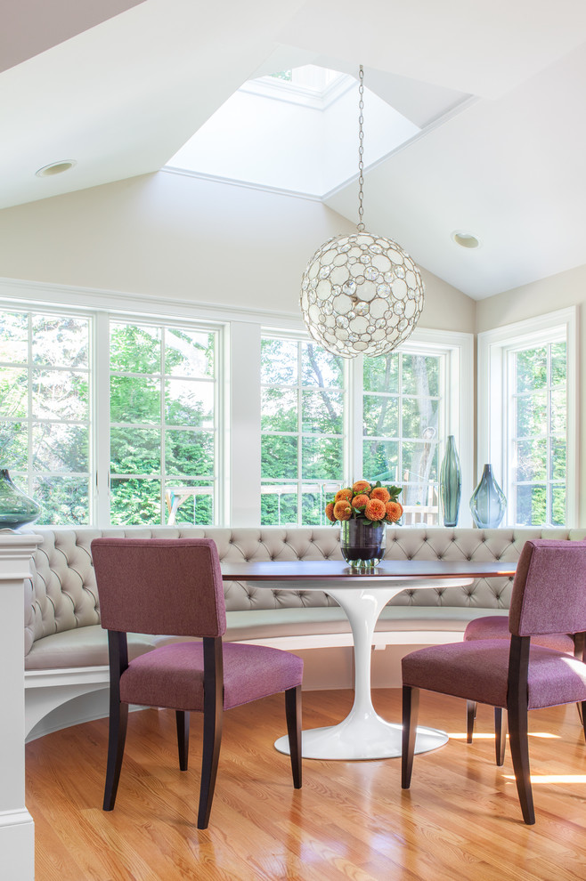 This is an example of a transitional dining room in Boston with white walls and light hardwood floors.
