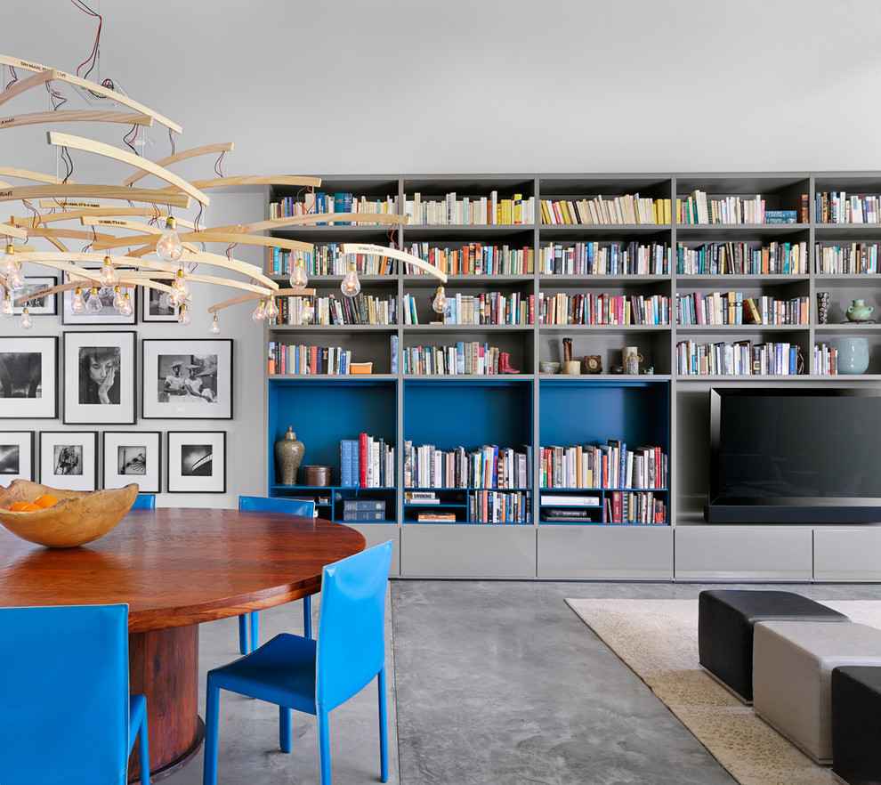 This is an example of a contemporary open concept living room in Austin with a library and white walls.