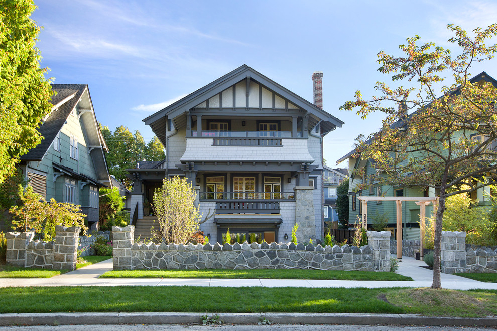 Inspiration for an arts and crafts three-storey grey house exterior in Vancouver with a gable roof.