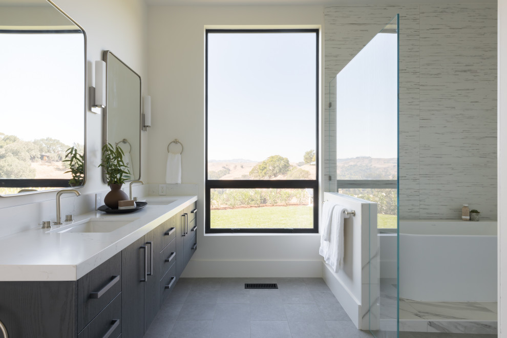 Large trendy master white tile and porcelain tile porcelain tile, gray floor and double-sink bathroom photo in San Francisco with flat-panel cabinets, gray cabinets, a one-piece toilet, white walls, an undermount sink, a hinged shower door, white countertops and a floating vanity