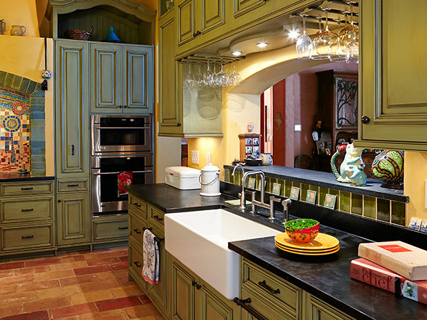 Design ideas for a large eclectic eat-in kitchen in Charleston with a farmhouse sink, raised-panel cabinets, green cabinets, green splashback, terra-cotta floors, with island and orange floor.