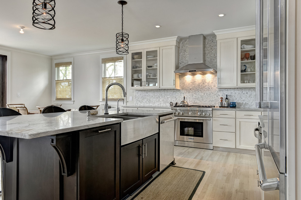 Inspiration for a mid-sized country l-shaped separate kitchen in Charleston with a farmhouse sink, shaker cabinets, white cabinets, marble benchtops, white splashback, mosaic tile splashback, stainless steel appliances, light hardwood floors and with island.