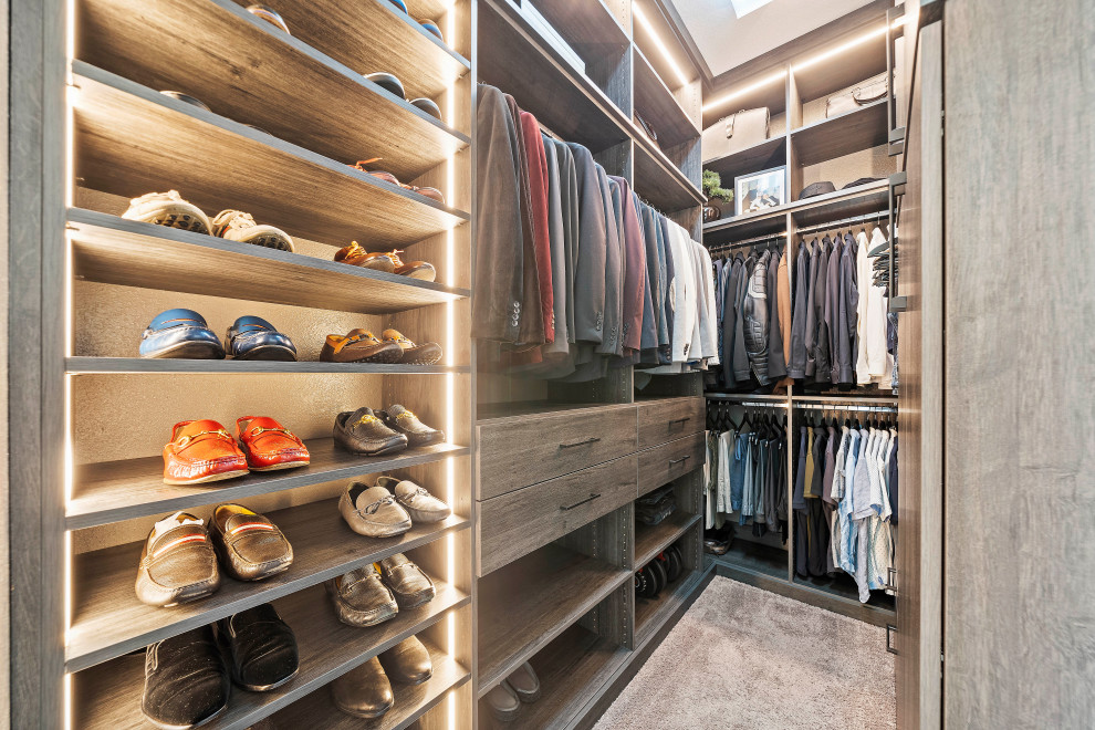 Photo of a large modern gender neutral walk-in wardrobe in Houston with carpet, grey floors, grey cabinets, a vaulted ceiling and feature lighting.