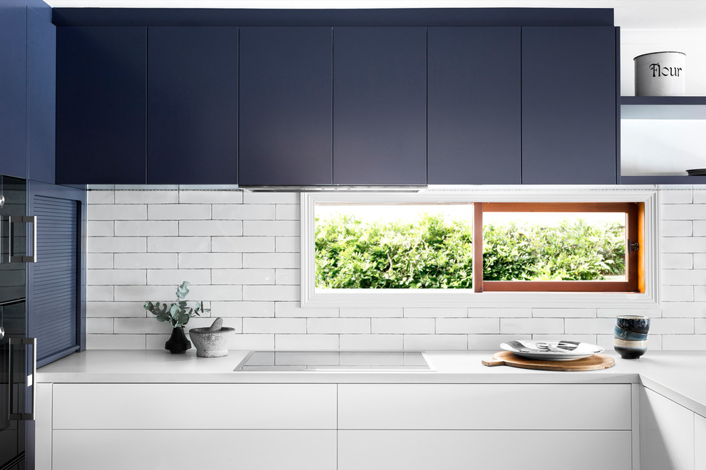 Photo of a mid-sized contemporary u-shaped eat-in kitchen in Melbourne with an undermount sink, flat-panel cabinets, blue cabinets, quartz benchtops, white splashback, window splashback, black appliances and dark hardwood floors.