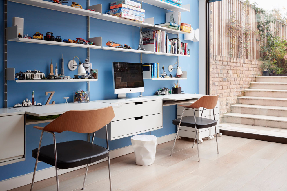 Aménagement d'une grande chambre d'enfant classique avec un bureau, un mur bleu, un sol en bois brun et un sol marron.