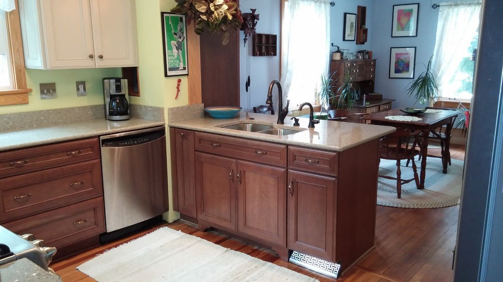 Photo of an u-shaped separate kitchen in Cleveland with medium wood cabinets, recycled glass benchtops, green splashback, stainless steel appliances, light hardwood floors and no island.