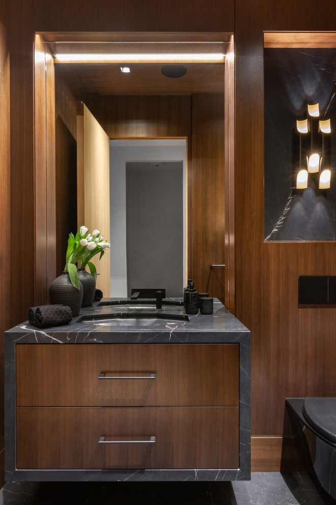 Idéer för att renovera ett litet funkis svart svart toalett, med släta luckor, skåp i mörkt trä, en toalettstol med hel cisternkåpa, bruna väggar, marmorgolv, ett nedsänkt handfat, bänkskiva i kvarts och svart golv