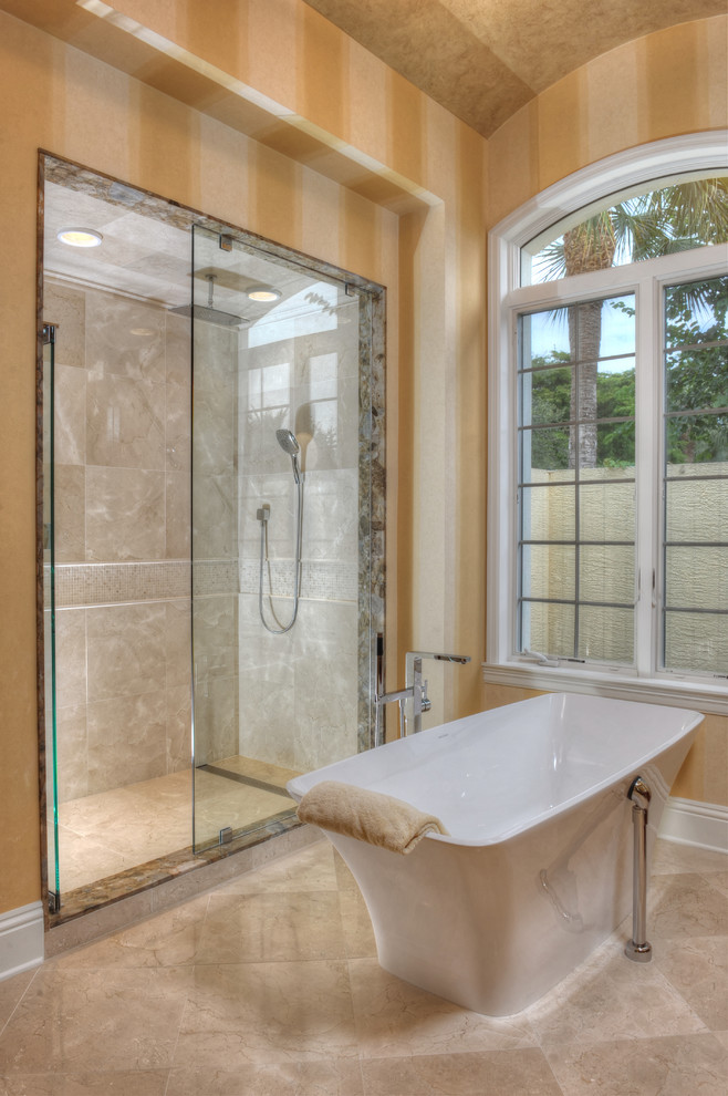 This is an example of a contemporary master bathroom in Miami with flat-panel cabinets, medium wood cabinets, a freestanding tub, a double shower, beige tile, ceramic tile, yellow walls, travertine floors, a vessel sink, granite benchtops and beige floor.