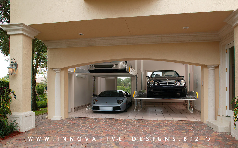 Example of a large tuscan attached three-car garage design in Miami