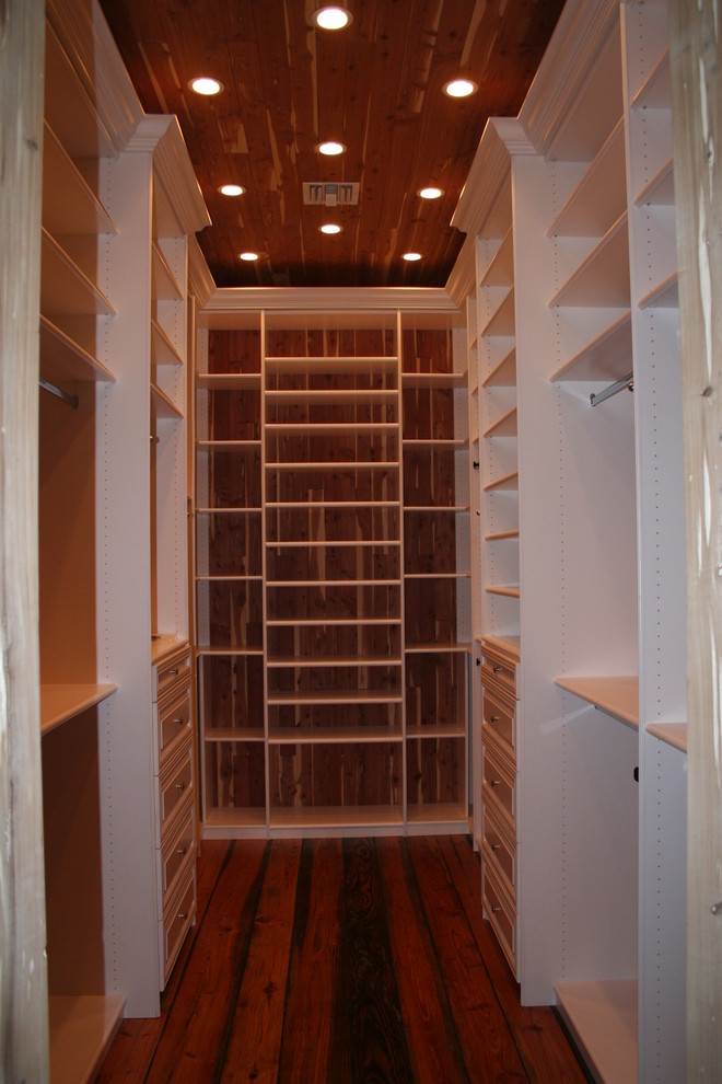 Photo of a large modern gender-neutral walk-in wardrobe in Miami with open cabinets, white cabinets and dark hardwood floors.