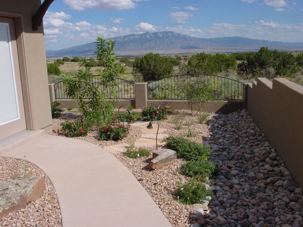 Design ideas for a small and desert look traditional backyard partial sun xeriscape for spring in Albuquerque with concrete pavers.