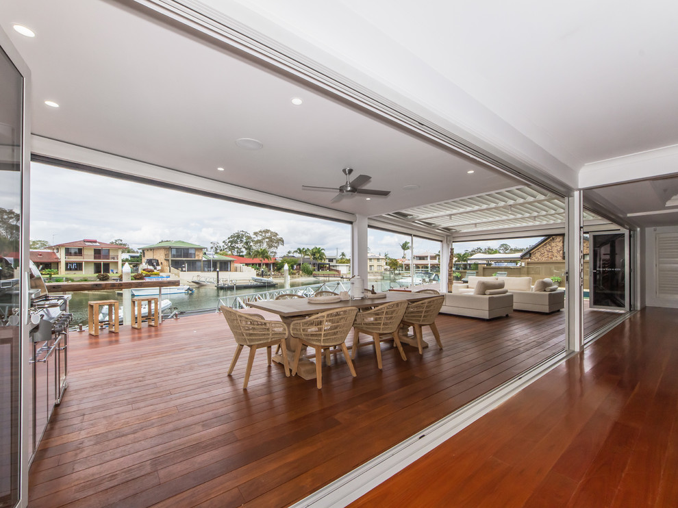 Inspiration for a large contemporary backyard deck in Brisbane with with dock and a roof extension.