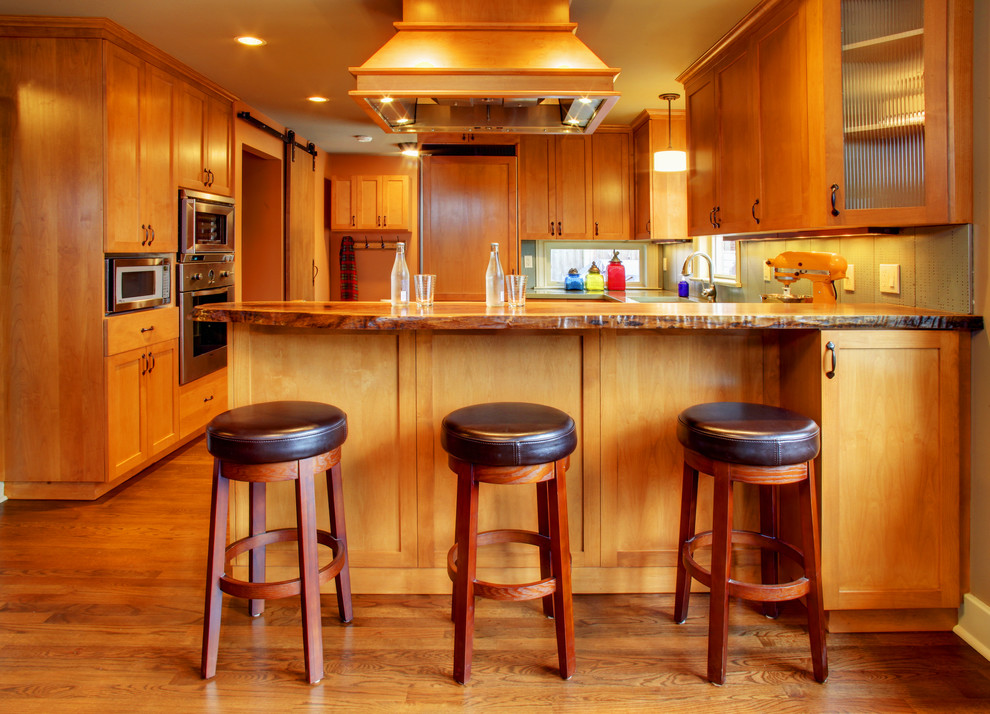 Example of a mid-sized transitional u-shaped dark wood floor eat-in kitchen design in Seattle with an undermount sink, shaker cabinets, medium tone wood cabinets, concrete countertops, green backsplash, ceramic backsplash, stainless steel appliances, gray walls and a peninsula
