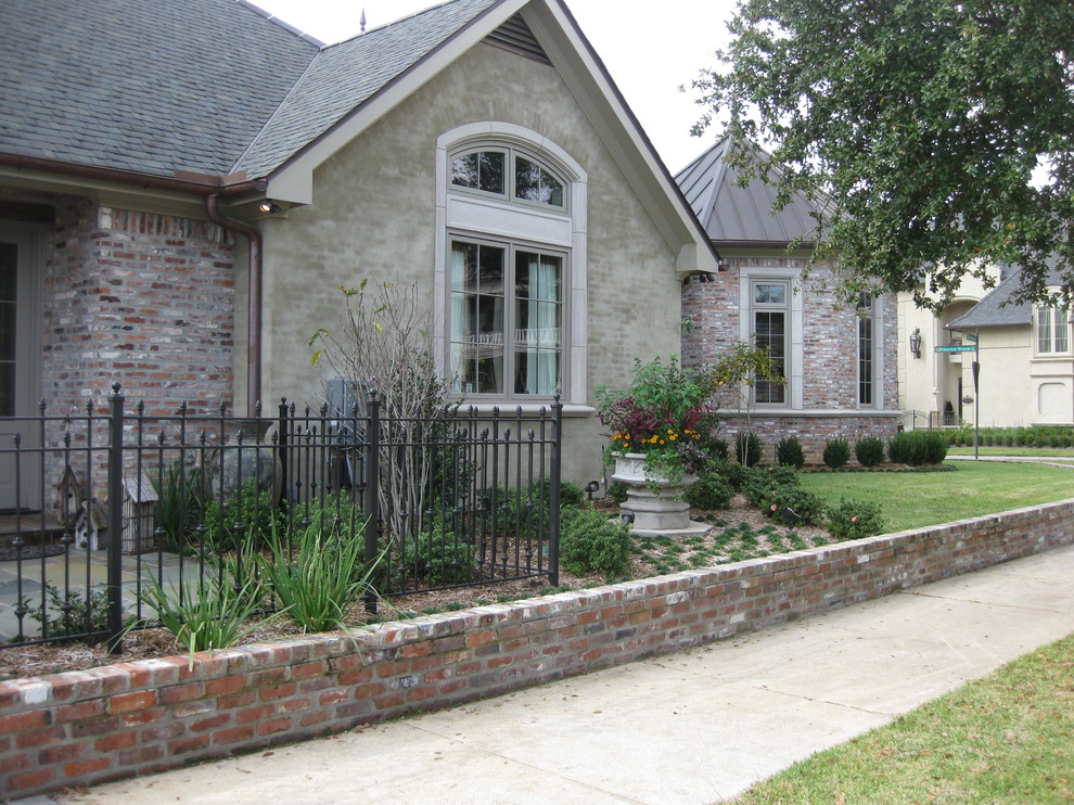 Photo of a small country front yard patio in New Orleans with natural stone pavers and a roof extension.