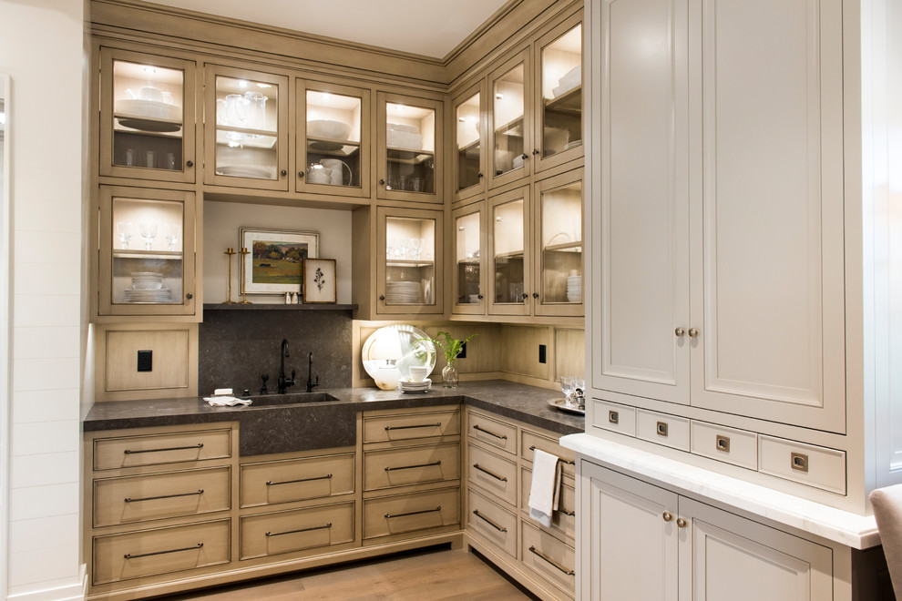 Photo of a traditional l-shaped kitchen pantry in Salt Lake City with an integrated sink, recessed-panel cabinets, distressed cabinets, grey splashback, light hardwood floors and beige floor.