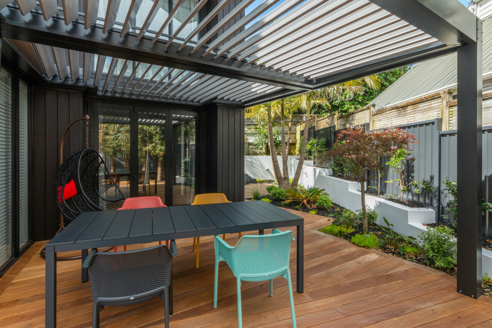 Design ideas for a contemporary deck in Auckland with metal railing, with privacy feature and a pergola.