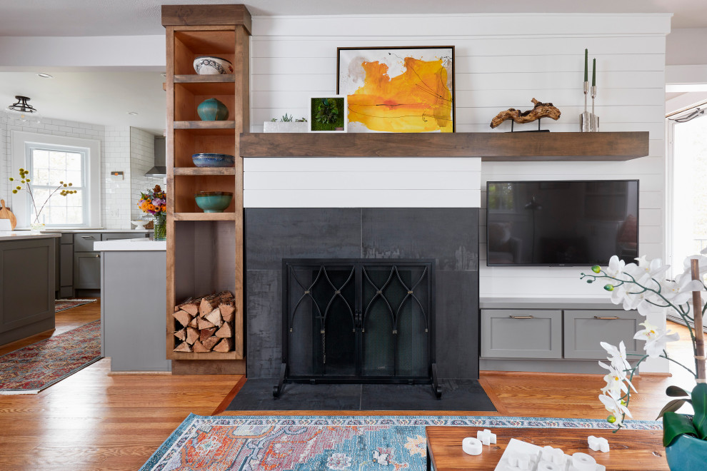 Inspiration for a mid-sized transitional open concept medium tone wood floor and brown floor living room remodel with white walls, a standard fireplace, a tile fireplace and a wall-mounted tv