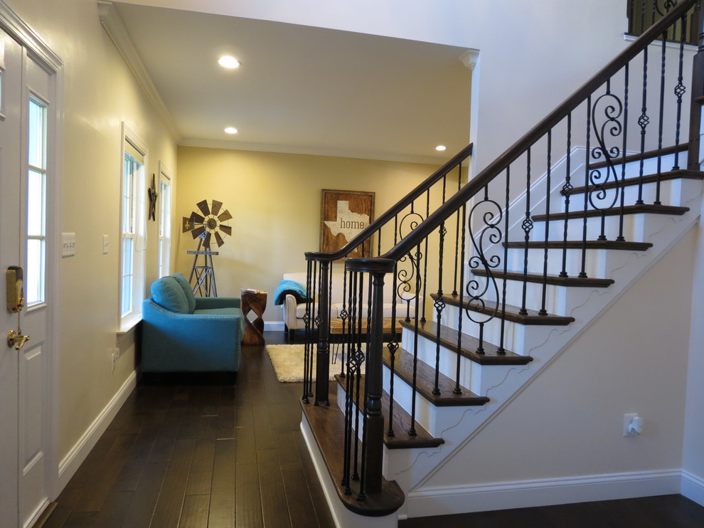 Example of a large transitional galley dark wood floor and brown floor kitchen design with a double-bowl sink, raised-panel cabinets, white cabinets, granite countertops, white backsplash, porcelain backsplash, stainless steel appliances and an island