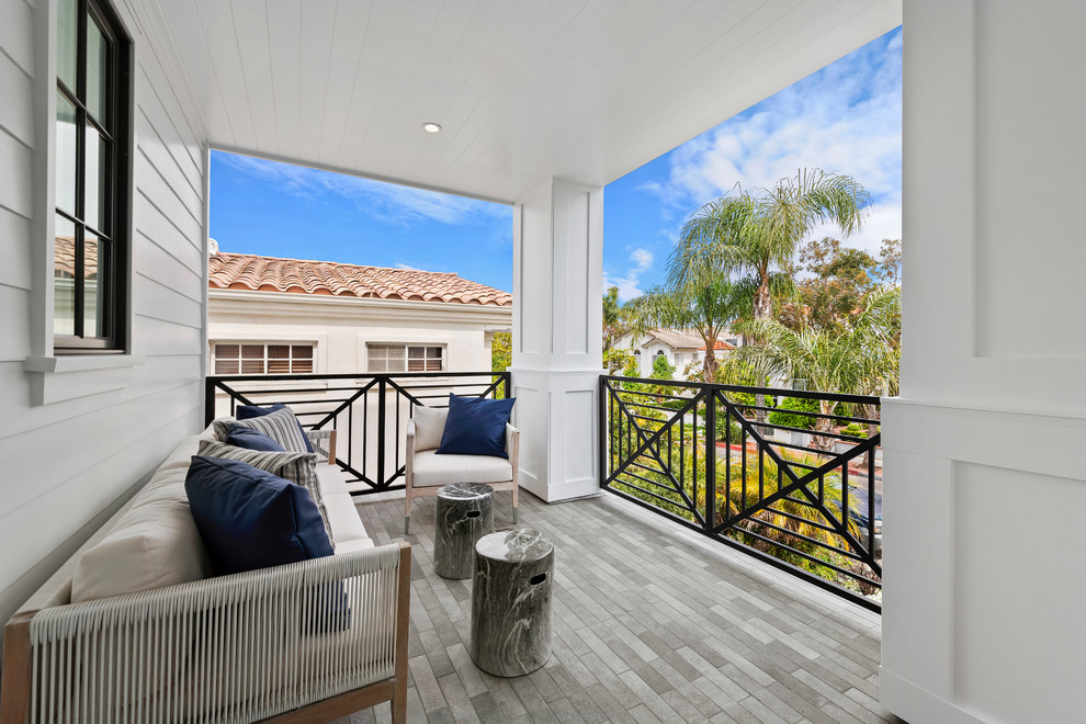 Mid-sized beach style balcony in Orange County with metal railing and a roof extension.