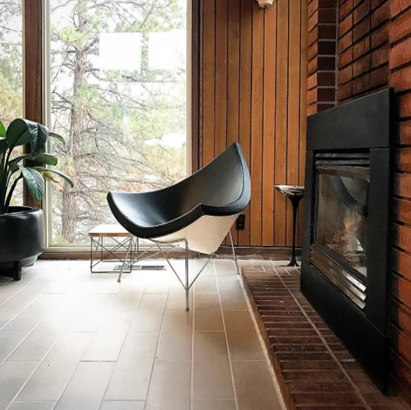 This is an example of a mid-sized midcentury formal open concept living room in Salt Lake City with brown walls, porcelain floors, a standard fireplace, a metal fireplace surround, no tv and brown floor.