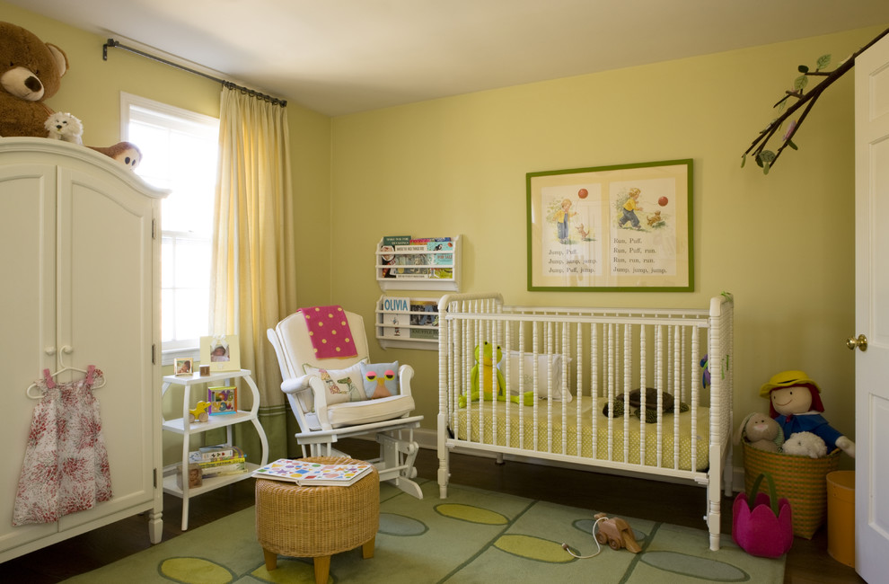 Photo of a traditional toddler room for girls in DC Metro with yellow walls and dark hardwood floors.