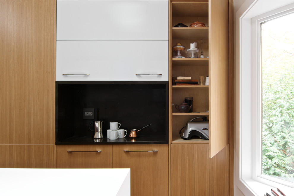 Inspiration for a small modern galley separate kitchen in Seattle with a single-bowl sink, flat-panel cabinets, light wood cabinets, quartz benchtops, white splashback, ceramic splashback, stainless steel appliances, light hardwood floors, with island and brown floor.