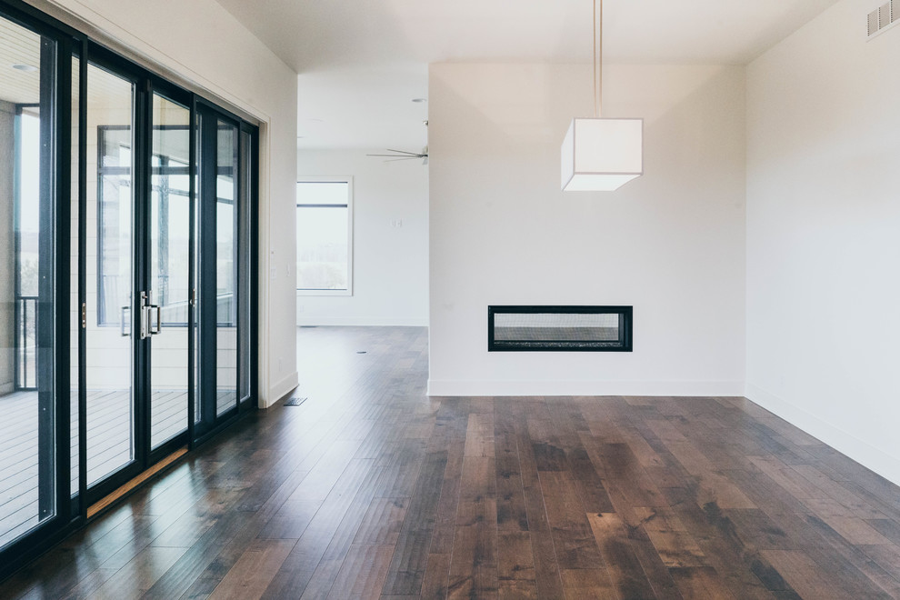 Transitional dark wood floor enclosed dining room photo in Omaha with a two-sided fireplace