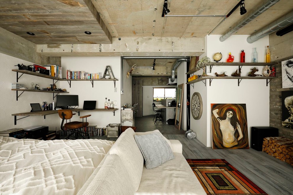 Esempio di una camera da letto industriale con pareti bianche, pavimento in legno massello medio e pavimento grigio