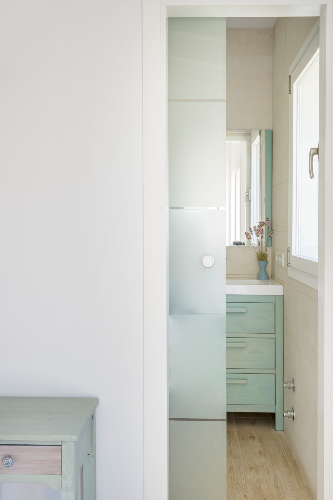 Immagine di una grande stanza da bagno padronale design con ante lisce, ante turchesi e un lavabo