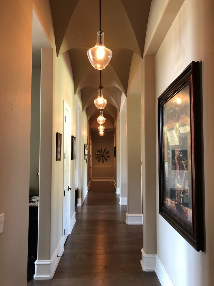 Example of a classic dark wood floor and brown floor hallway design in Dallas with beige walls
