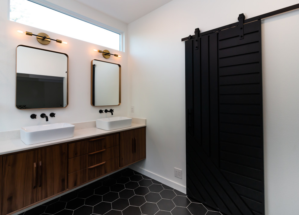 Photo of a midcentury bathroom in Orange County with flat-panel cabinets, brown cabinets, a freestanding tub, a corner shower, black and white tile, porcelain tile, white walls, porcelain floors, a vessel sink, engineered quartz benchtops, black floor, a hinged shower door, white benchtops, a shower seat, a double vanity and a floating vanity.