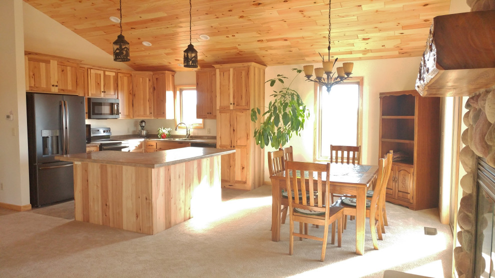 Design ideas for a mid-sized country l-shaped open plan kitchen in Other with a drop-in sink, flat-panel cabinets, light wood cabinets, laminate benchtops, black appliances, ceramic floors, with island, beige floor, brown benchtop and wood.