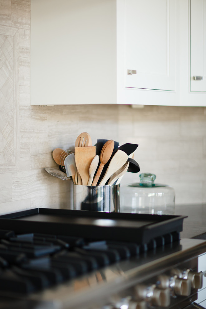 Example of a large transitional l-shaped light wood floor open concept kitchen design in Orange County with a farmhouse sink, beaded inset cabinets, white cabinets, beige backsplash, stone tile backsplash, stainless steel appliances, gray walls and an island