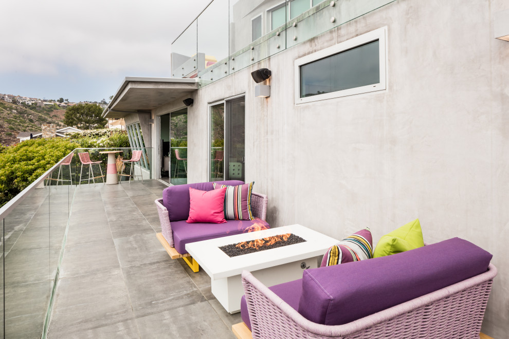 Photo of a large contemporary backyard deck in Orange County with a fire feature.