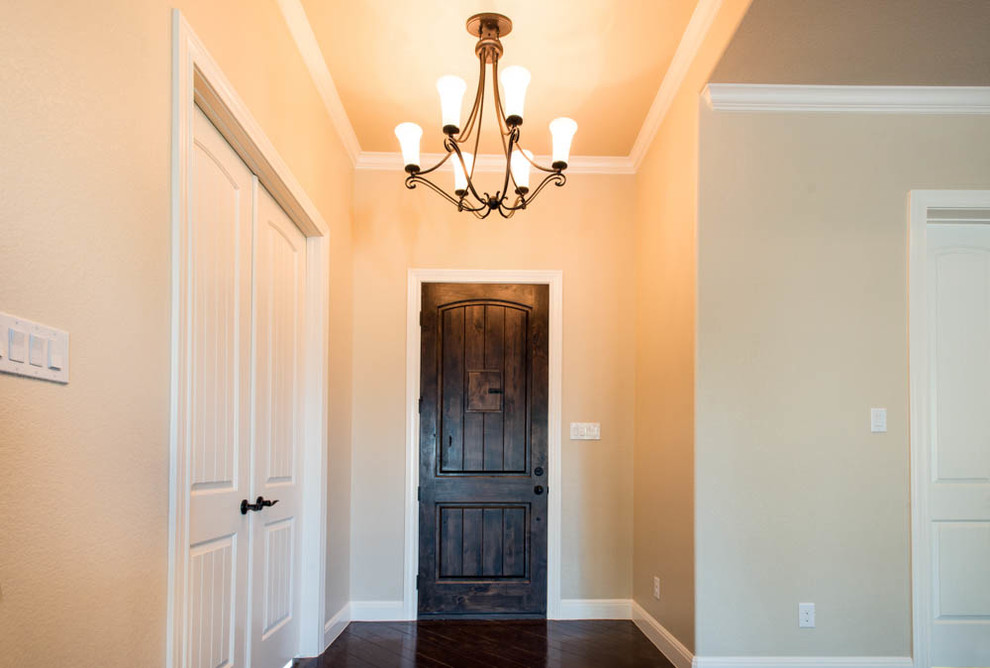 Mid-sized traditional front door in Austin with beige walls, concrete floors, a single front door and a dark wood front door.