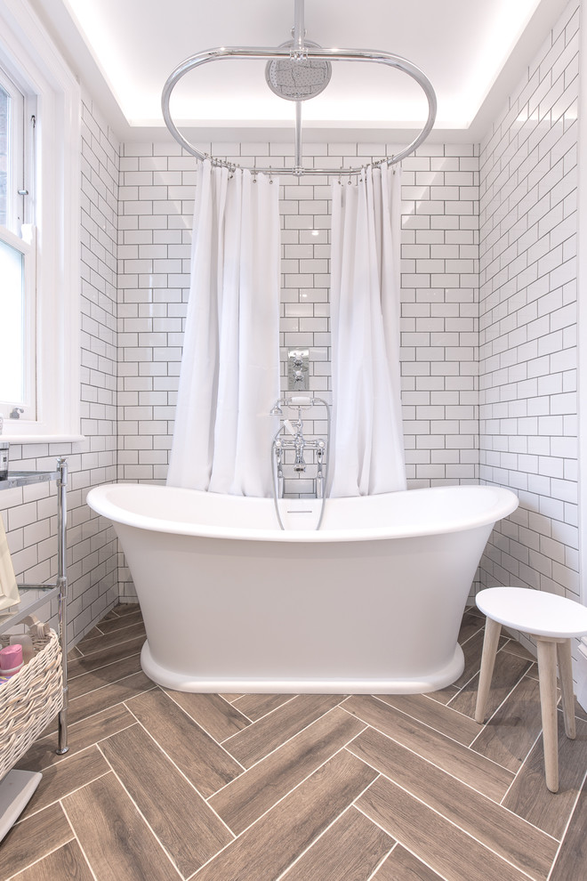Transitional bathroom in Hertfordshire with a freestanding tub, white tile, subway tile and brown floor.