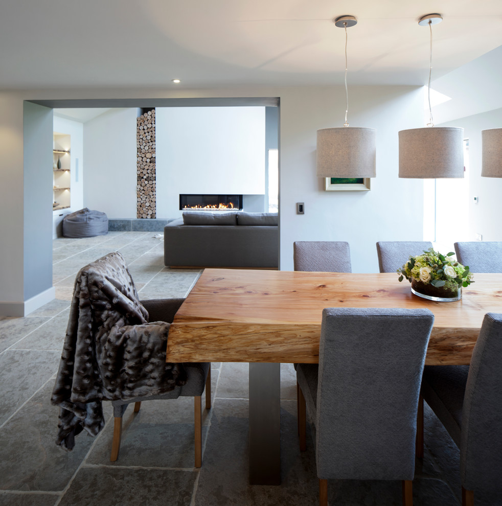 Photo of a large contemporary dining room in Cheshire with white walls and limestone floors.