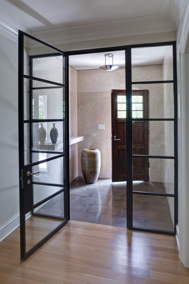 This is an example of a small contemporary entryway in Chicago with beige walls, porcelain floors, a single front door and a medium wood front door.