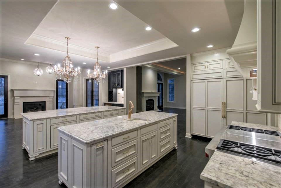 Huge transitional u-shaped eat-in kitchen photo in Columbus with paneled appliances, recessed-panel cabinets, white cabinets, granite countertops and two islands