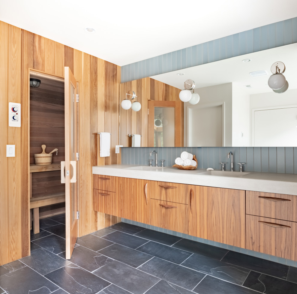 Retro sauna bathroom in Portland with flat-panel cabinets, medium wood cabinets, a freestanding bath, blue tiles, ceramic tiles, slate flooring, concrete worktops, grey floors, grey worktops, an enclosed toilet, double sinks, a floating vanity unit, a vaulted ceiling, wood walls and an integrated sink.