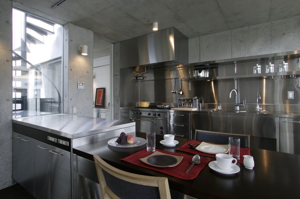 Inspiration for an industrial galley kitchen in Tokyo Suburbs with a single-bowl sink, flat-panel cabinets, stainless steel cabinets, stainless steel benchtops, metallic splashback, stainless steel appliances and a peninsula.