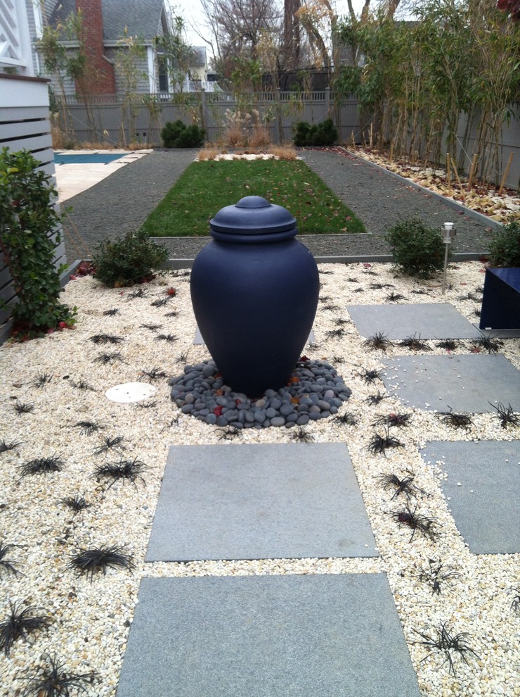 Photo of a small beach style backyard garden in New York with a water feature and natural stone pavers.