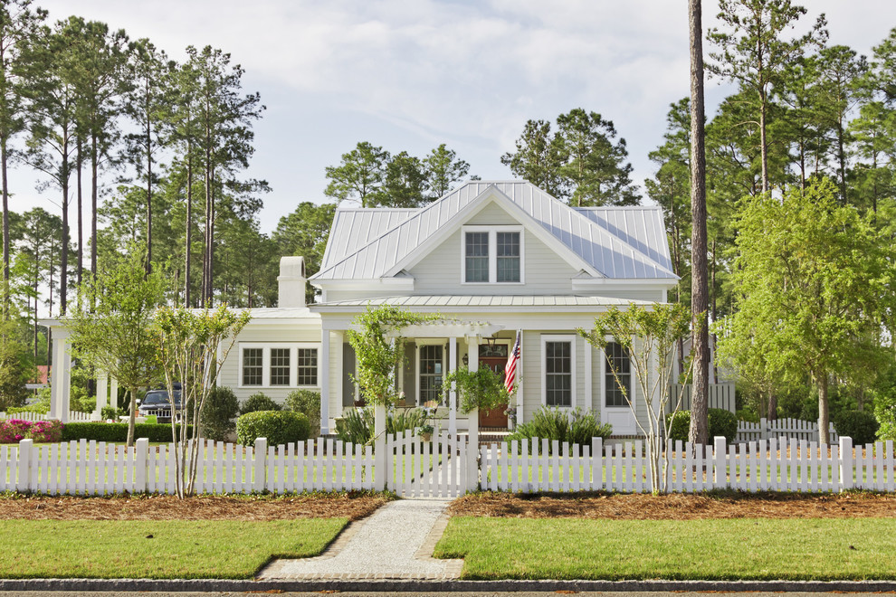 Photo of a country white exterior in Atlanta with wood siding, a gable roof and a metal roof.