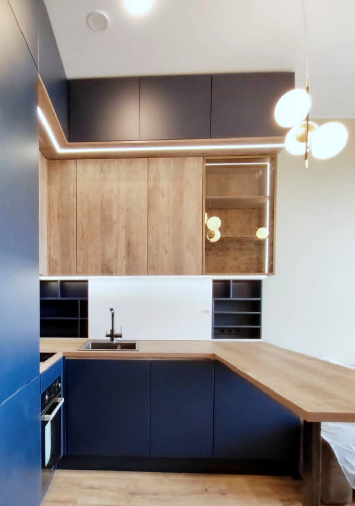 Inspiration for a large urban u-shaped open plan kitchen in Moscow with a built-in sink, flat-panel cabinets, blue cabinets, laminate countertops, blue splashback, black appliances, laminate floors, a breakfast bar and multicoloured worktops.