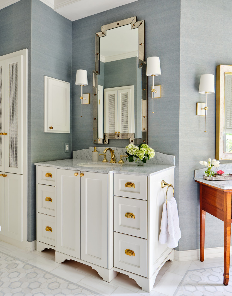 Photo of a traditional master bathroom in Austin with white cabinets, a freestanding vanity, blue walls, porcelain floors, marble benchtops, white floor, grey benchtops, a niche, a single vanity, wallpaper and recessed-panel cabinets.